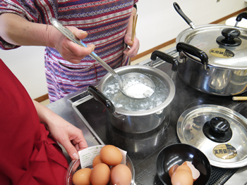 こちらはポーチドエッグ作り。お玉に卵を割ってそーっと。