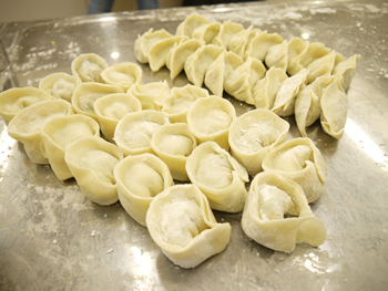 見て下さい！皆さんの力作。手前が水（茹で）餃子用、奥が焼き餃子用と包み方をちょっと工夫してこんな仕上りに。焼き上がり・茹で揚がりが楽しみですね。