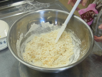 ドーナツ作りスタート！粉を入れたら切るように混ぜ合わせ、粉っぽさがなくなったら、手でヒビがないようになめらかに丸くまとめる。ここで1ＰＯＩＮＴ！パンのようにしたい時はイースト菌を入れましょう！ただし発酵時間が必要になります。